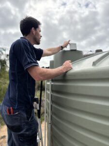 Mike from Think Water, Capes Region repairs a rain gauge at the white-bellied frog rehydration site.