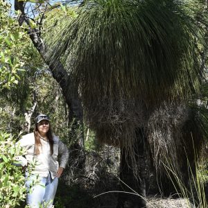 A mature grass tree (Xanthorrhoea sp.) towers over South West NRM Technical Officer Jade Riley in Wilyabrup, where a conservation covenant helps protect an established area of native bushland for the long term.
